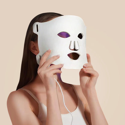 Mulher utilizando a Máscara Facial de Terapia de Luz LED da Aluna para um tratamento de pele avançado em casa.